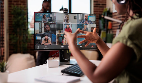 A lady engaged in a Zoom call on a computer screen featuring multiple participants