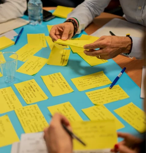 A close up shot of people working together with sticky notes.