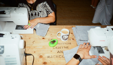 Photograph of people sewing, using sewing machines